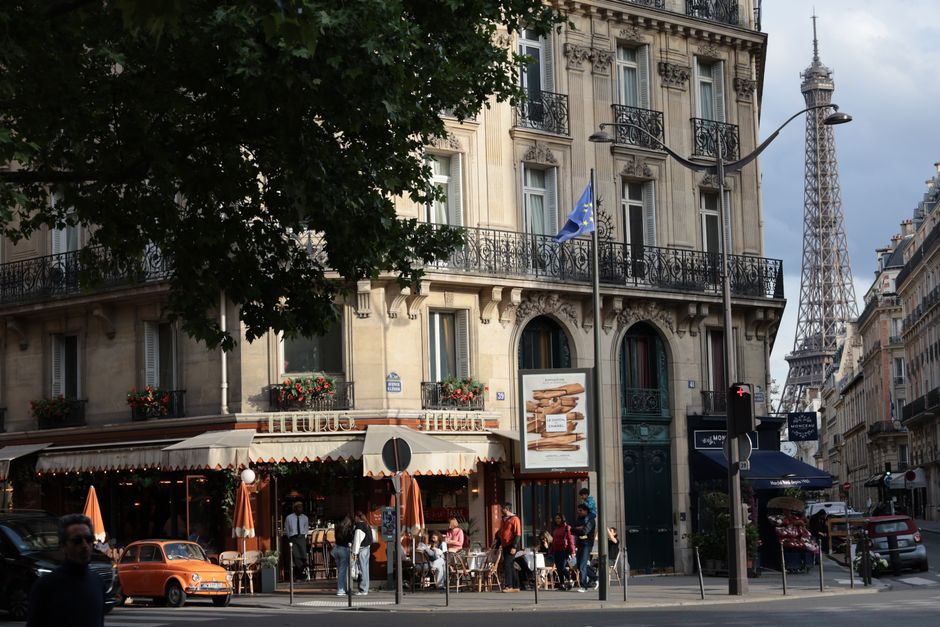 Quaint Parisian café scene with a view of the iconic Eiffel Tower, embodying the city's classic appeal.